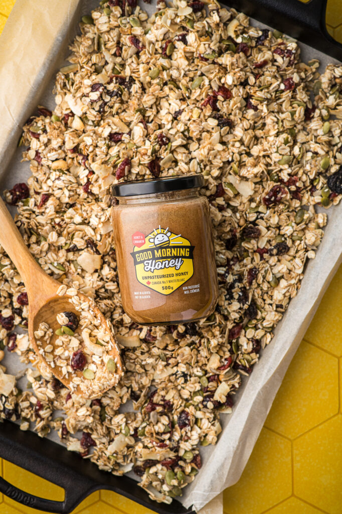 A pan of granola and a jar of Good Morning Honey cinnamon honey.