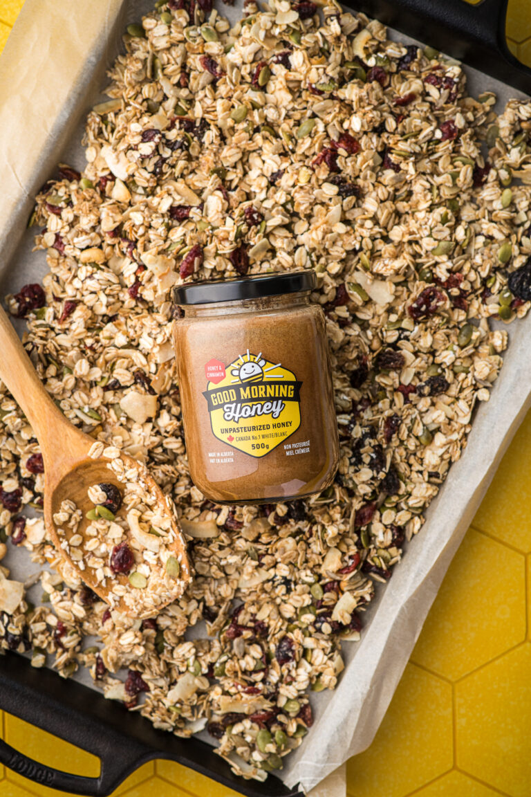 A pan of granola and a jar of Good Morning Honey cinnamon honey.